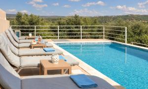 a swimming pool with couches and a patio with at Cretan Breeze Villa Heated Pool in Dhrámia