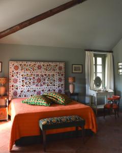a bedroom with a bed with an orange bedspread at Biondelli Boutique Winery in Cazzago San Martino