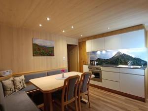 a living room with a table and a kitchen at Pension Edelweiss in Damuls
