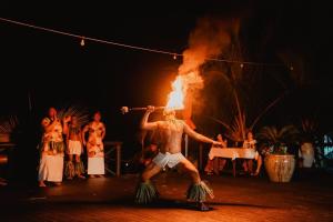 a man is holding a fire torch in a circus at Le Lagoto Resort & Spa in Fagamalo
