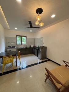 a kitchen with a table and a ceiling fan at GRAYSTONE HOMESTAY, Omassery in Tāzhekkod