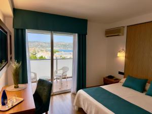 a hotel room with a bed and a large window at Hotel Villa Naranjos in Jávea +15 photos