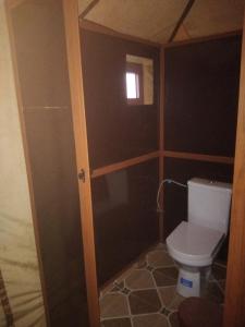 a small bathroom with a toilet and a window at Merzouga camelle trike bivoage in Merzouga +17 photos