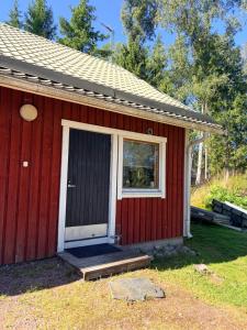 a red house with a door and a window at Vierashuone 1 