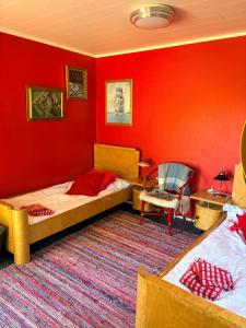 a room with two beds and a red wall at Vierashuone 1  +8 photos