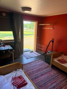 a bedroom with two beds and a table and a window at Vierashuone 1 