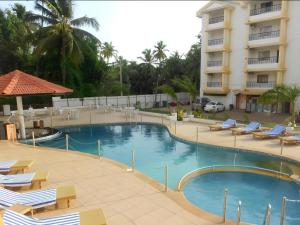 a swimming pool in front of a hotel at Hotel Colva Kinara in Colva