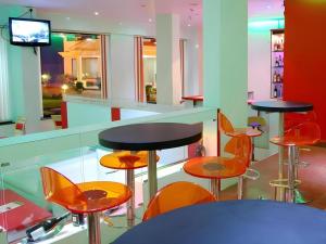 a restaurant with tables and chairs and a television at Hotel Colva Kinara in Colva