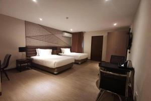 a hotel room with two beds and a television at Maxx Hotel Ortigas in Manila +79 photos