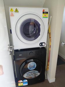 a washer and dryer in a room at Relaxing Beach shack at the Footprints complex in Preston Beach