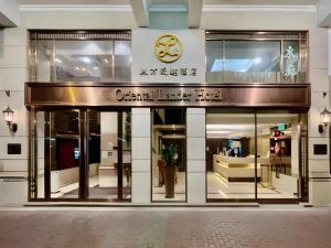 eine Ladenfront mit einer Uhr darauf in der Unterkunft Oriental Lander Hotel in Hongkong