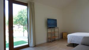 a bedroom with a bed and a tv and a sliding glass door at Lorca Express Suite in Lorca