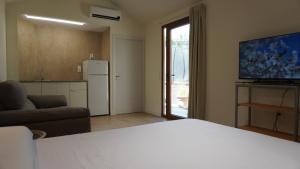 a room with a bed and a kitchen with a refrigerator at Lorca Express Suite in Lorca