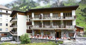 a large building with tables and chairs in front of it at Hôtel Grand-Combin in Fionnay