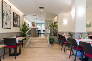 um restaurante com mesas e cadeiras e uma escadaria em Hostal La Vila em Olot