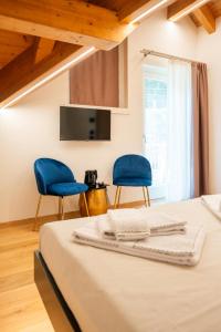 a bedroom with two blue chairs and a bed at Hotel Villa Amabile in Villa dʼAllegno +11 photos