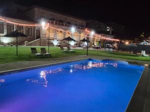 a swimming pool in front of a building at night at El Linar in Burgohondo