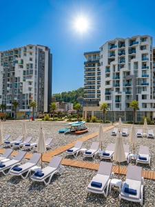 a group of lounge chairs and umbrellas on a beach at Студия у чистейшего Моря! in Gonio
