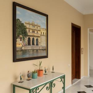 a painting of a building on a wall with a table at Chez Lavania - A Boutique Stay in Udaipur