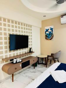 a living room with a television on a wall at Hotel Yagnik Inn in Rajkot