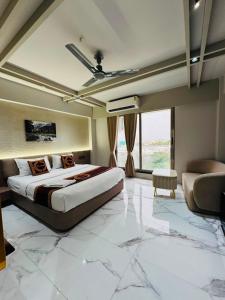 a bedroom with a king sized bed and a couch at Hotel Yagnik Inn in Rajkot