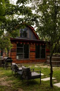 a log cabin with two benches in front of it at Netri SPA in Zofʼyuvka
