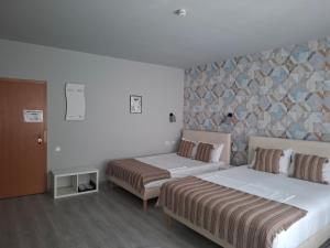 a hotel room with two beds and a wall at Pensiunea Paloma 3 stele Brasov in Braşov
