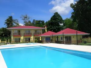 a resort with a swimming pool in front of a building at Caimito Beach Hotel in Ichon