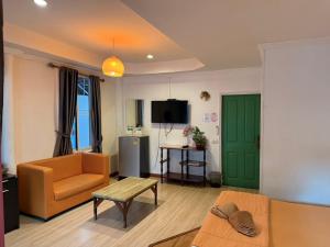 a living room with a couch and a green door at ลุงชีพบ้านพัก เกาะล้านLoongcheeb House in Ko Larn