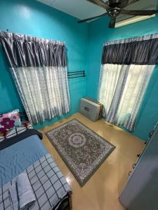 a bedroom with blue walls and a bed with a rug at Homestay D Makmur UNIT 1 in Mersing +23 photos