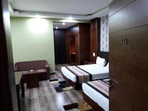 a hotel room with two beds and a couch at Mayor Hotel in Siliguri +131 photos