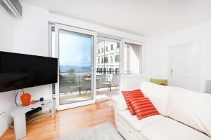 - un salon blanc avec un canapé blanc et une grande fenêtre dans l'établissement Apartment Jelena, à Zadar