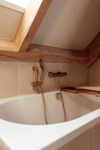 a bath tub in a bathroom with a wooden ceiling at Granny's B&B in Kapelle +89 photos