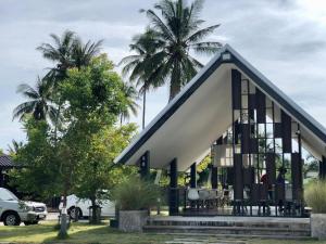 a small house with a black and white roof at CoCo Tree Resort in Thap Sakae