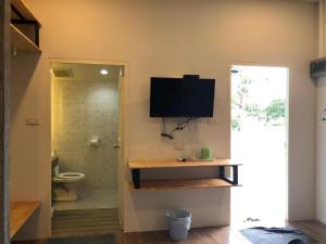 a bathroom with a toilet and a television on the wall at CoCo Tree Resort in Thap Sakae +213 photos