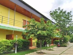 a yellow building with a tree in front of it at Wanarom Resort in Ban Maklua Kao