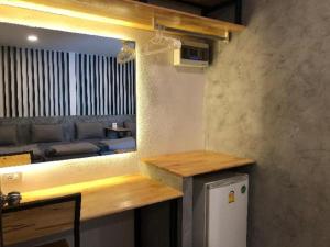 a kitchen with a couch and a table and a refrigerator at CoCo Tree Resort in Thap Sakae