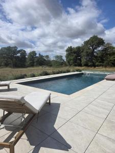 a swimming pool with a bench on a patio at Domaine du Riadoux in Bonneuil