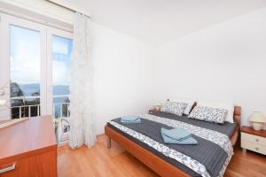 a bedroom with a bed and a large window at Jelena - Spacious Sea View Apartment - Old Town Zadar in Zadar