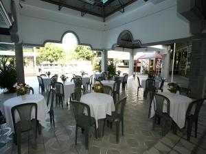 a dining room with white tables and chairs at Splash Mountain Resort & Hotel in Forestry