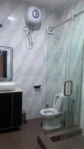 a bathroom with a shower with a toilet and a camera at Emirates Star Hotel & Suites in Asaba +25 photos