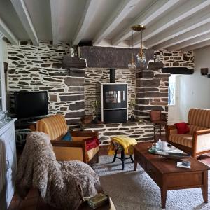 a living room with a stone wall at la guichardaye in Tréal