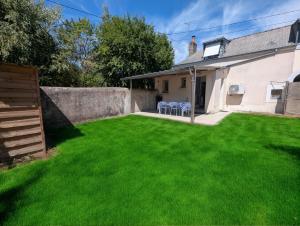 a yard with green grass and a house at Maison dans quartier calme proche centre-ville in Château-Gontier