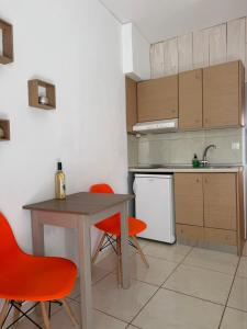 a kitchen with a table and two orange chairs at Zachos studio in Heraklio