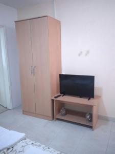 a bedroom with a cabinet and a television on a table at Studio apartmani AHUS in Petrovac na Moru