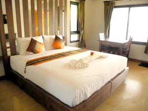 a large bed with white sheets and pillows in a room at Eitanic Resort in Ban Don Tako