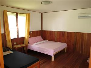a small bedroom with a bed and two windows at Mayas Native Garden Resort in Basdiot