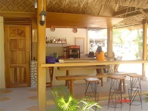 a kitchen with a wooden table and stools at Mayas Native Garden Resort in Basdiot