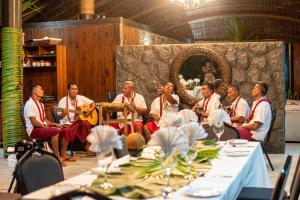 a group of men sitting around a table with instruments at Le Lagoto Resort & Spa in Fagamalo