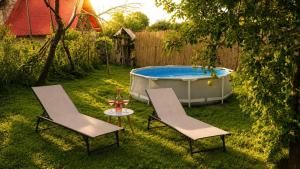 two chairs and a table and a tub in a yard at Blue Cottage in Şpring